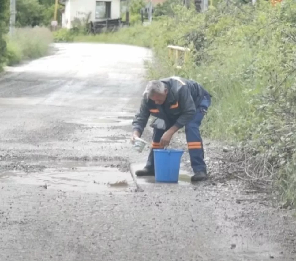 Samo u BiH: Radnik kanticom od pavlake izbacuje vodu iz rupe koju treba asfaltirati